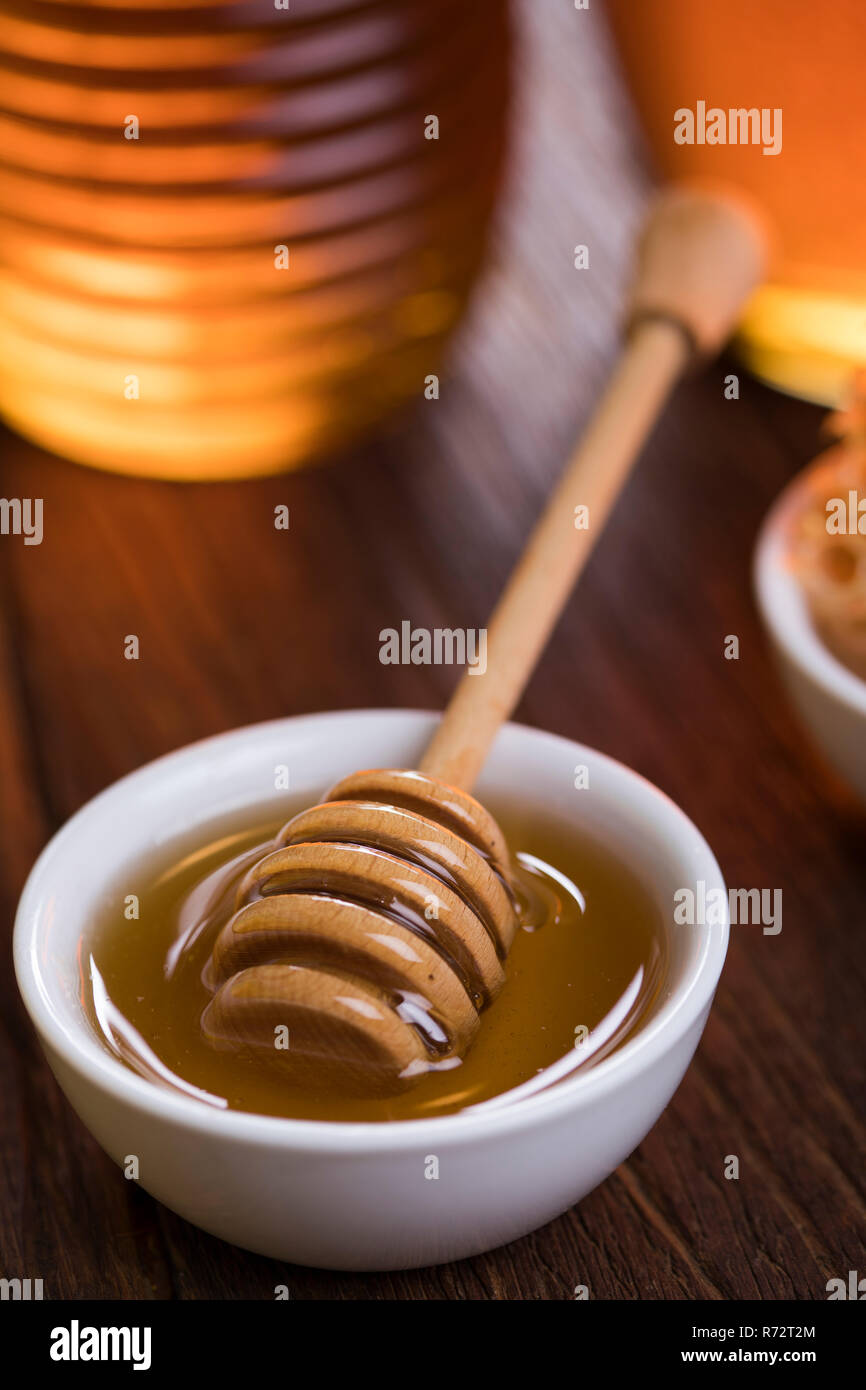 Honey jar with dipper and flowing honey Stock Photo Alamy
