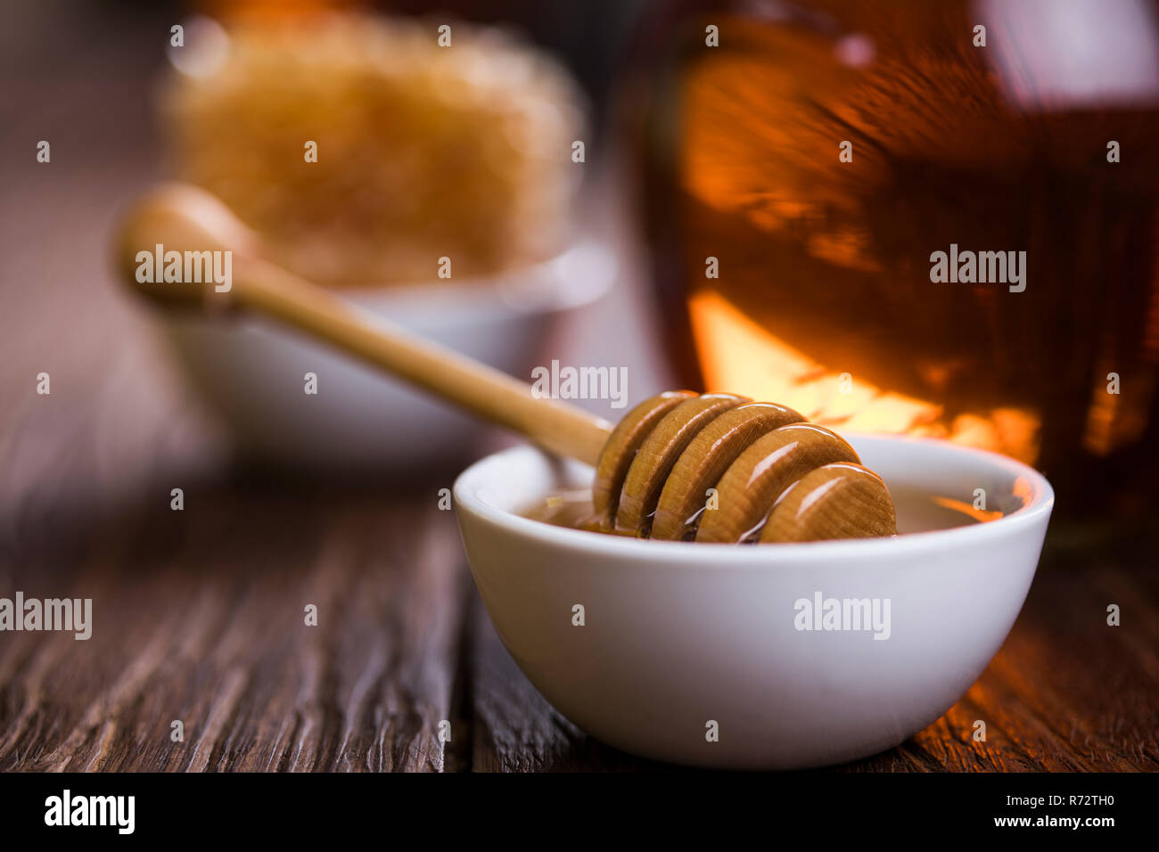 Honey jar with dipper and flowing honey Stock Photo Alamy