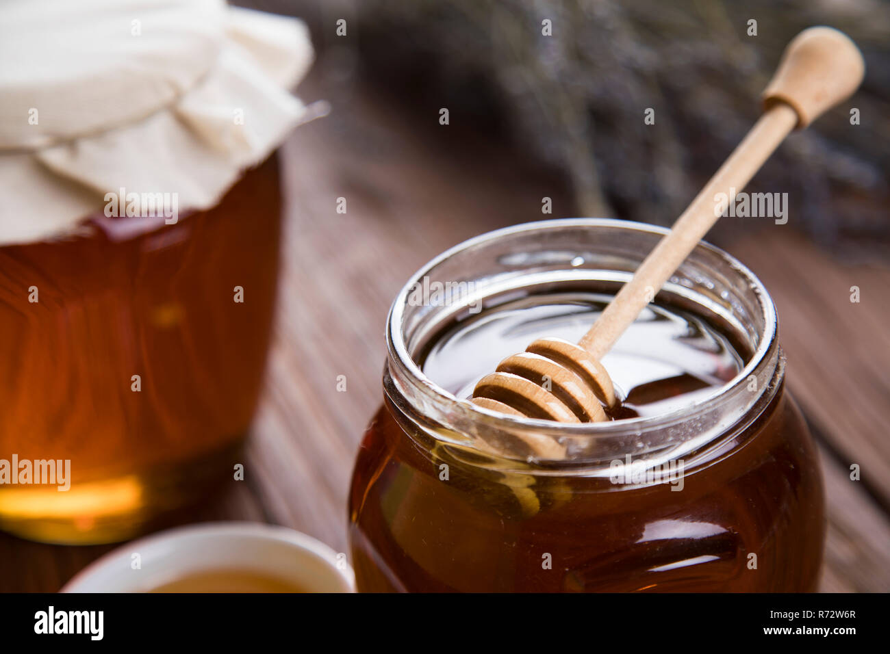 Honey jar with dipper and flowing honey Stock Photo Alamy