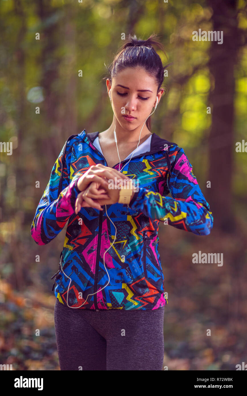 fitness Young Girl jogging Wearing Smartwatch and Wireless Earphones