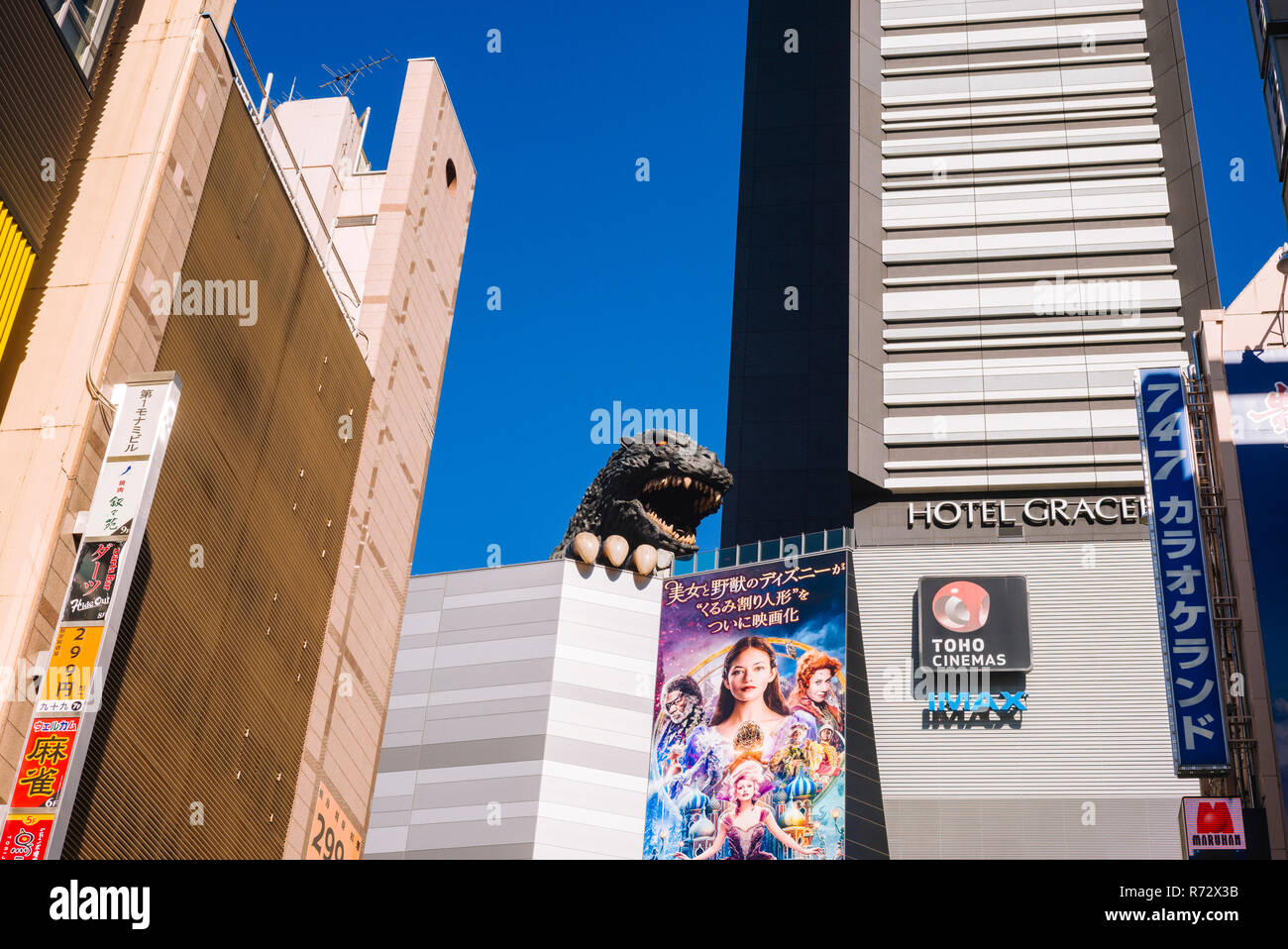 Kabukicho, Shinjuku, Tokyo: Godzilla peeping from highrise facade between advertising billboards, 25. November 2018 Stock Photo