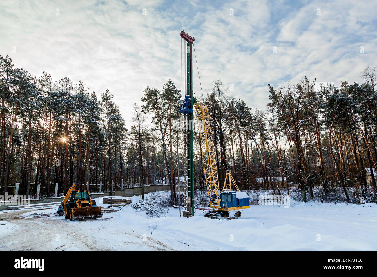 Excavator with a drill installation for drilling holes in the ground