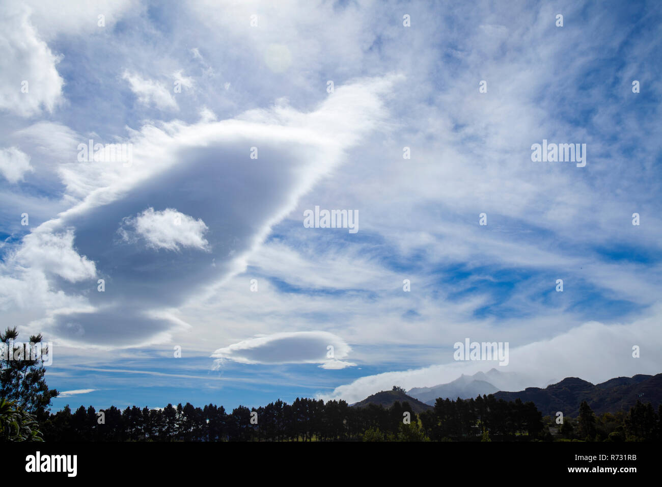 cloudscape over Gran Canaria, including some forming lenticular clouds Stock Photo
