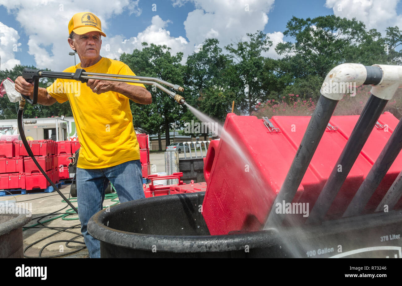 A Southern Baptist Disaster Relief volunteer rinses a cambro food transport crate used to deliver food after a flood in Baton Rouge, Louisiana. Stock Photo