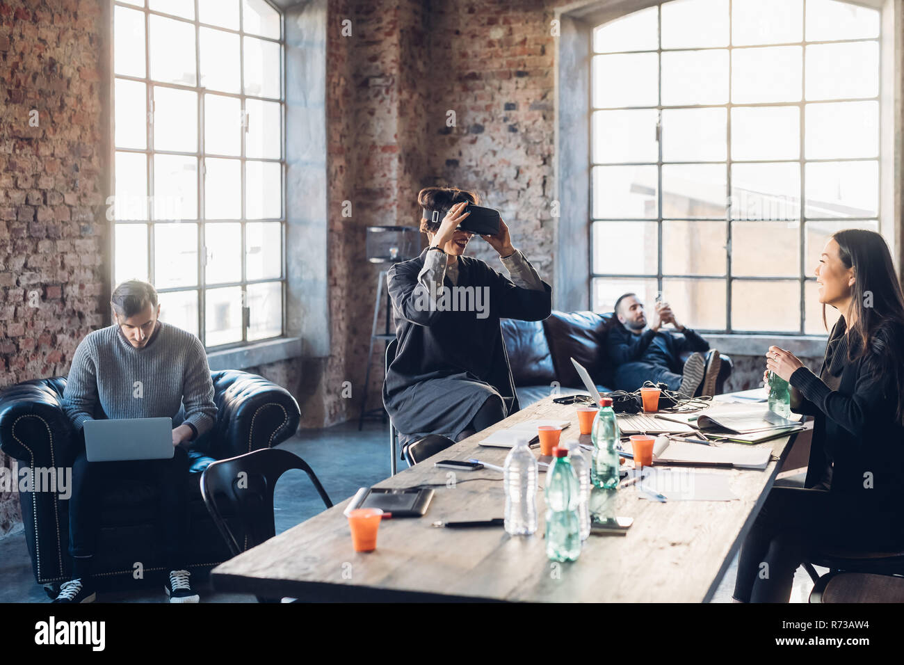 Designers testing virtual reality headset in communal space in studio Stock Photo