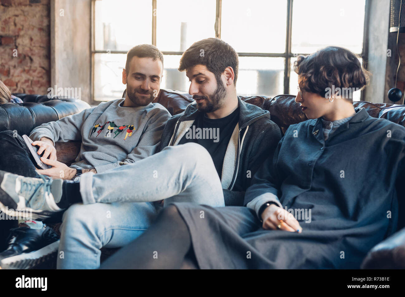 Designers taking break on sofa in studio Stock Photo Alamy