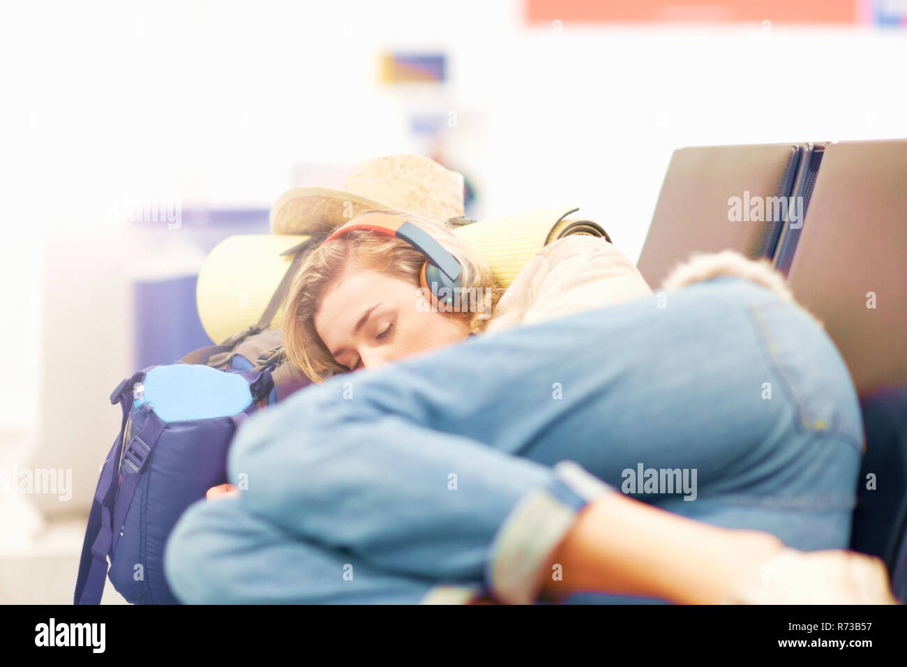 Young woman at airport, sleeping on seating in departure lounge Stock Photo Alamy