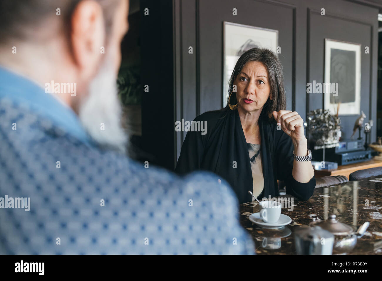 Couple in discussion over coffee in kitchen Stock Photo