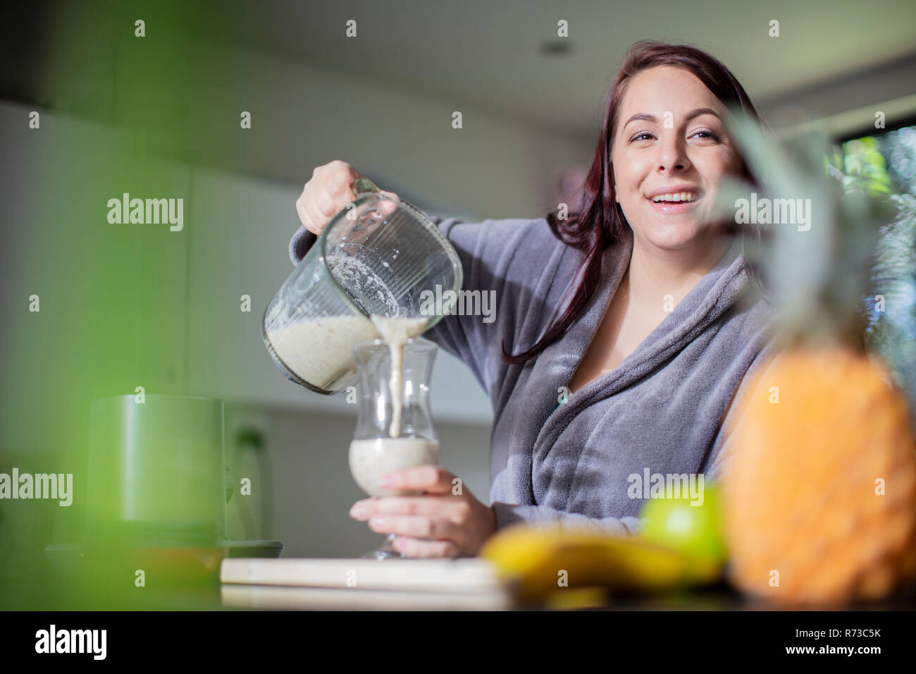 Woman having smoothie for breakfast at home Stock Photo