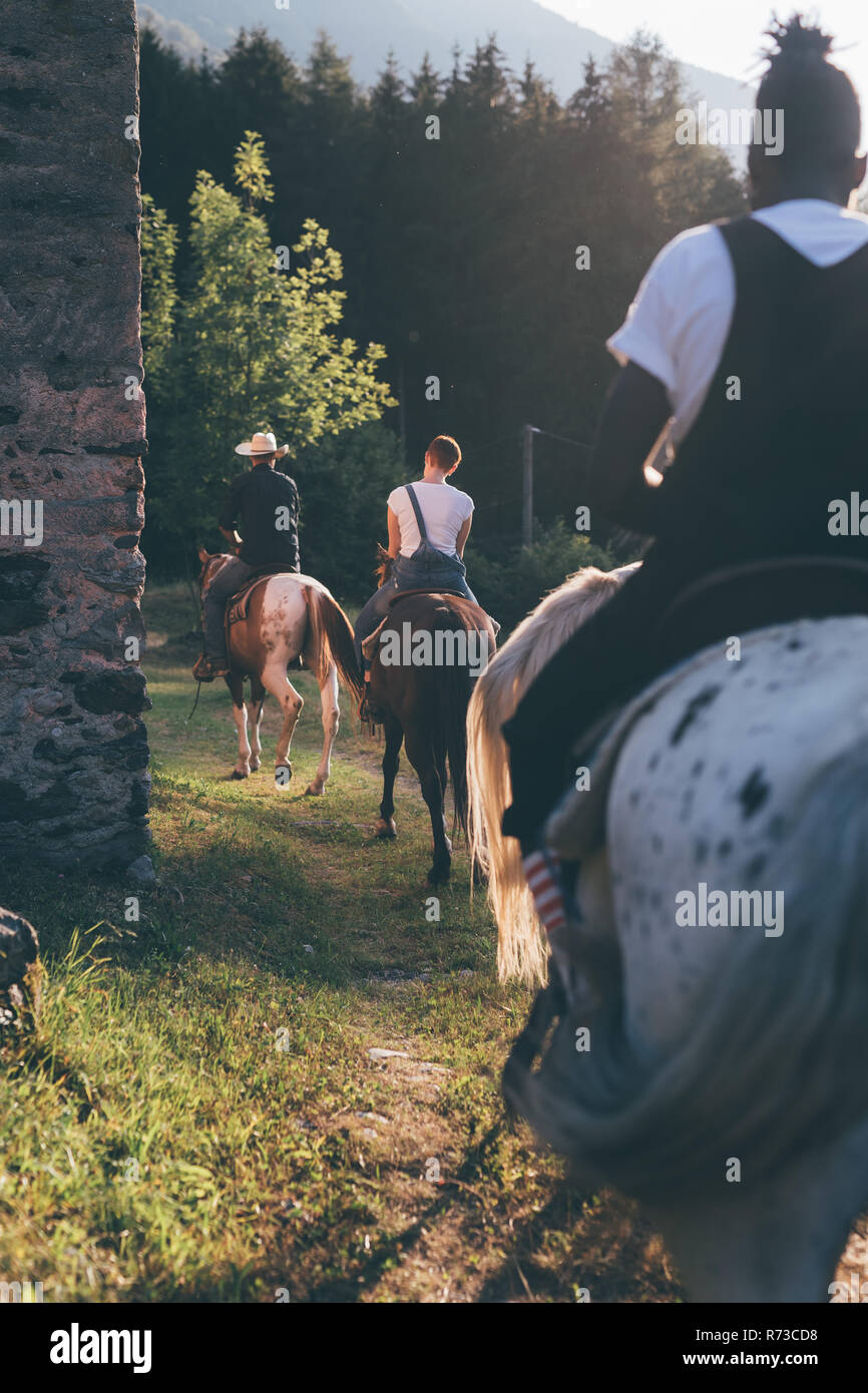 Young adults riding on rural track, rear view, Primaluna, Trentino-Alto Adige, Italy Stock Photo