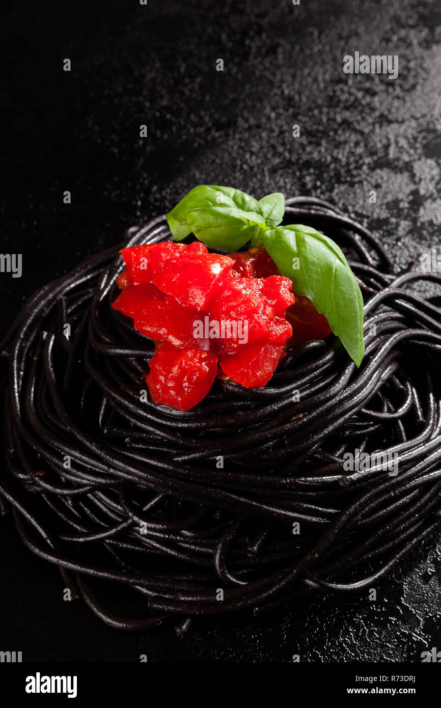 Black spaghetti with red tomato sauce Stock Photo - Alamy