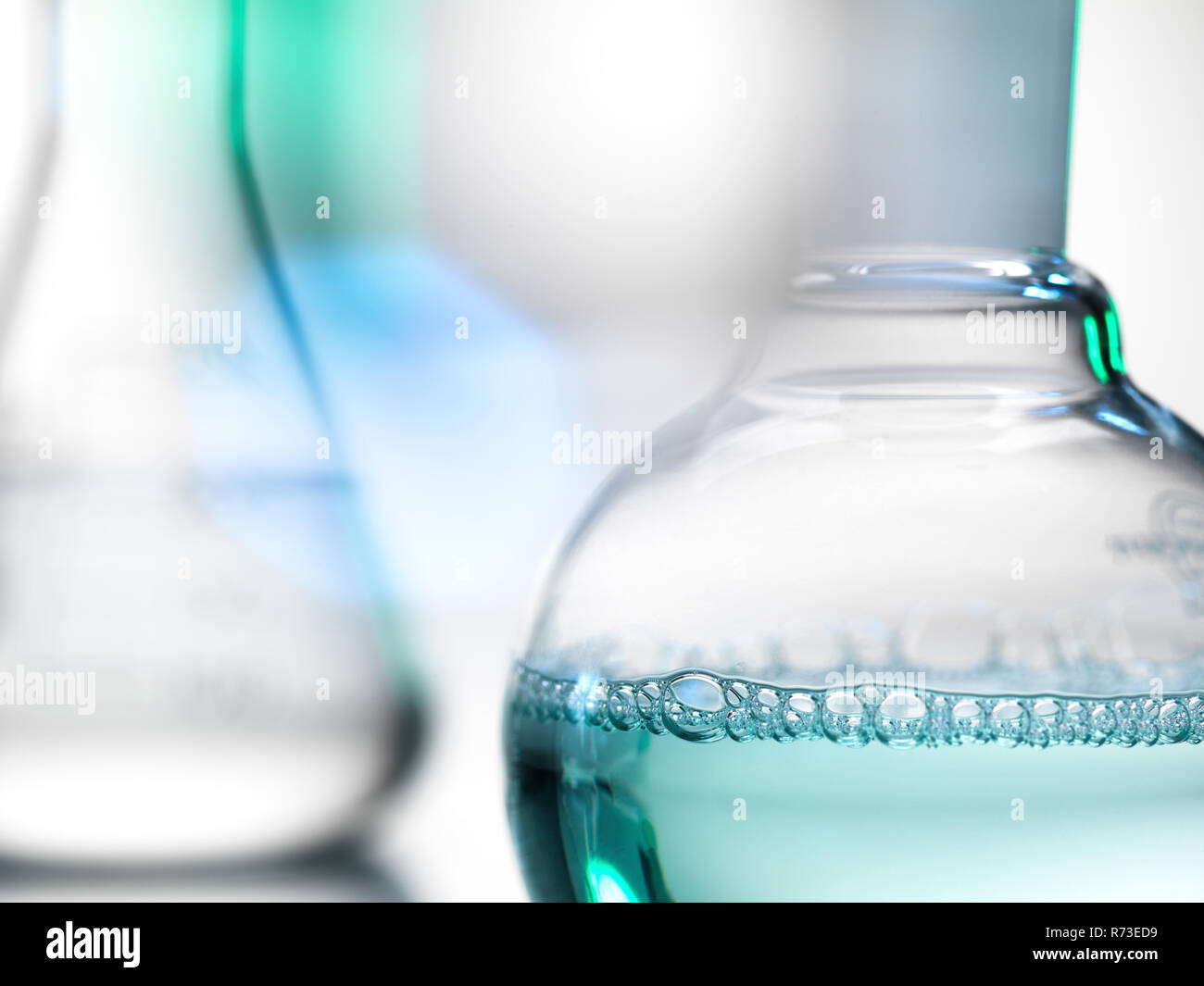 Laboratory beakers containing chemical formulas Stock Photo