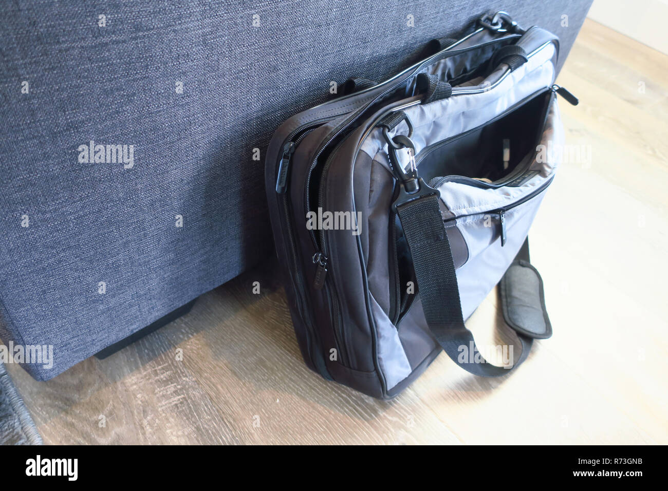 A laptop bag leaned up against a couch. Stock Photo