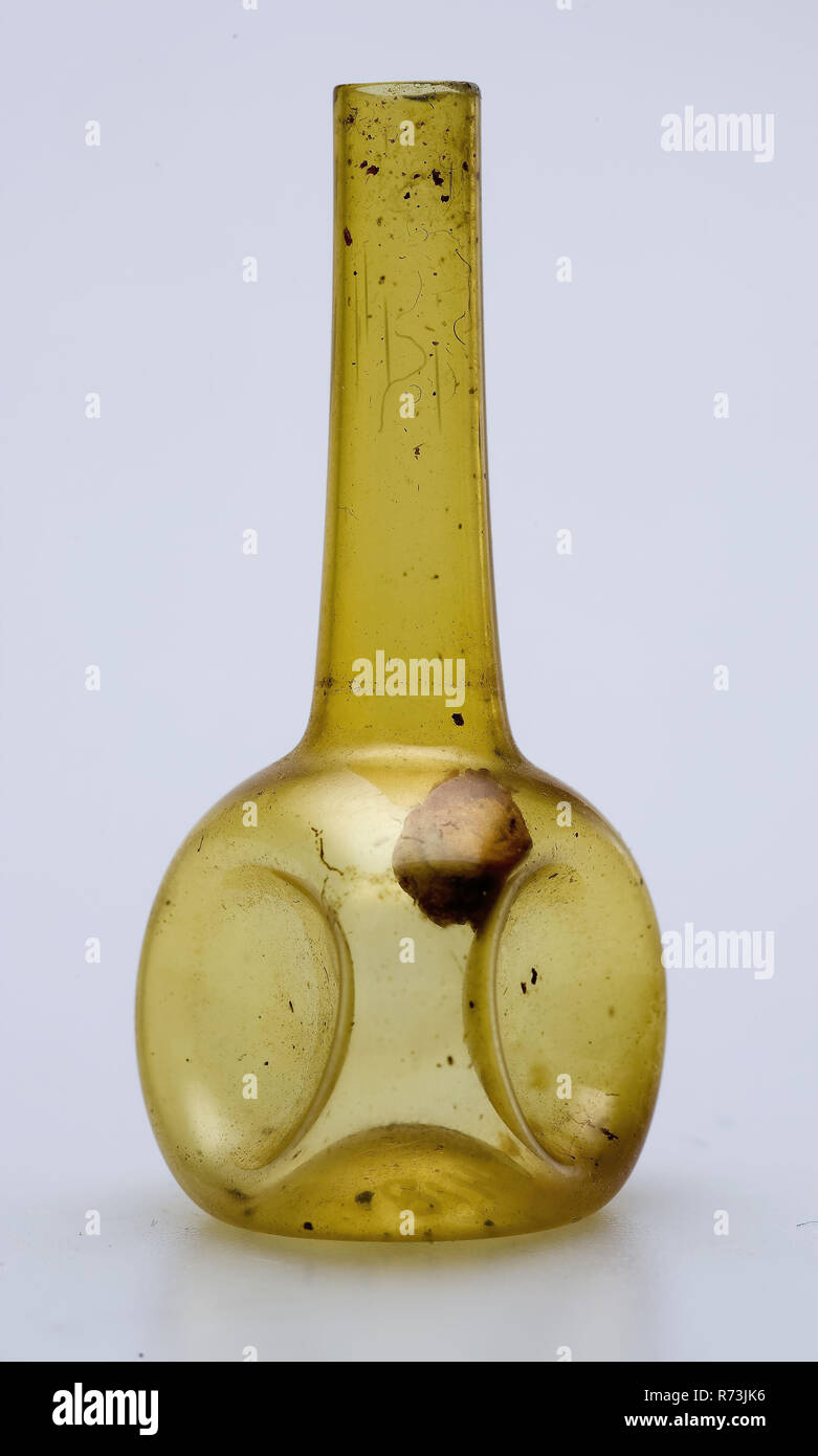 Miniature (toy?) Bottle, bottle holder soil find glass cork, free blown Miniature (toy?) Bottle in clear yellow glass (shaft & globe shape). Stowed bottom. Round belly that has received three-sided shape through impressions. Long cylindrical neck archeology toys? Stock Photo