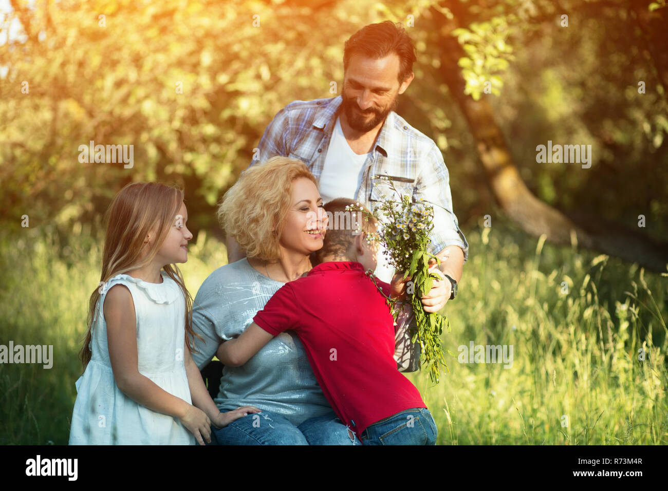 Portrait of young woman in wheelchair hugging her family Stock Photo