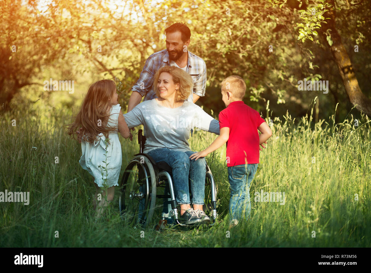 Children run to their disabled mother in the park Stock Photo Alamy
