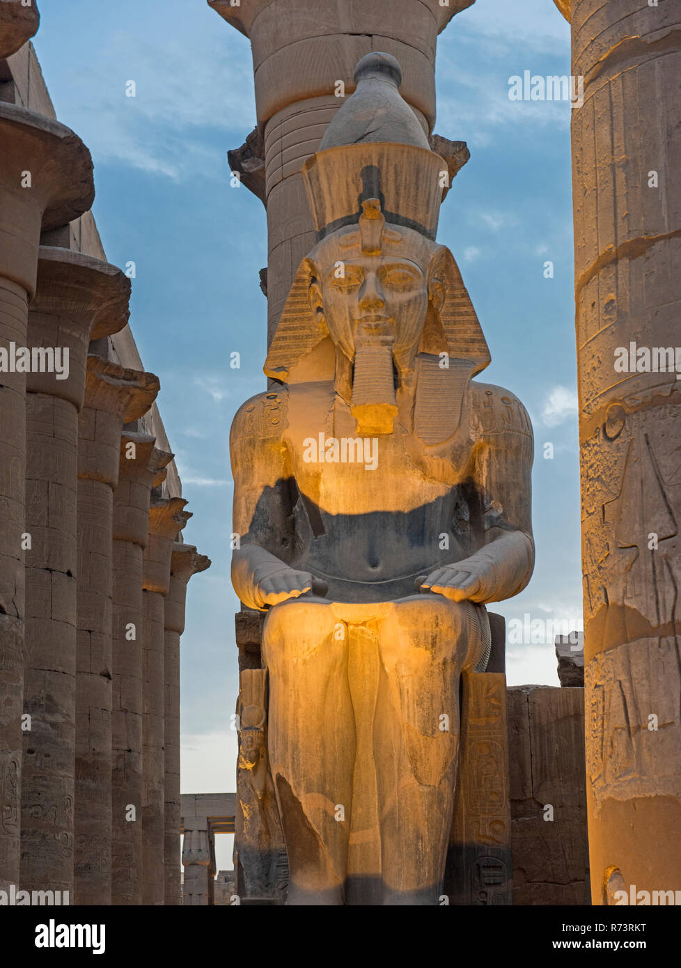 Large statue of Ramses II lit up at dusk in ancient egyptian Luxor ...