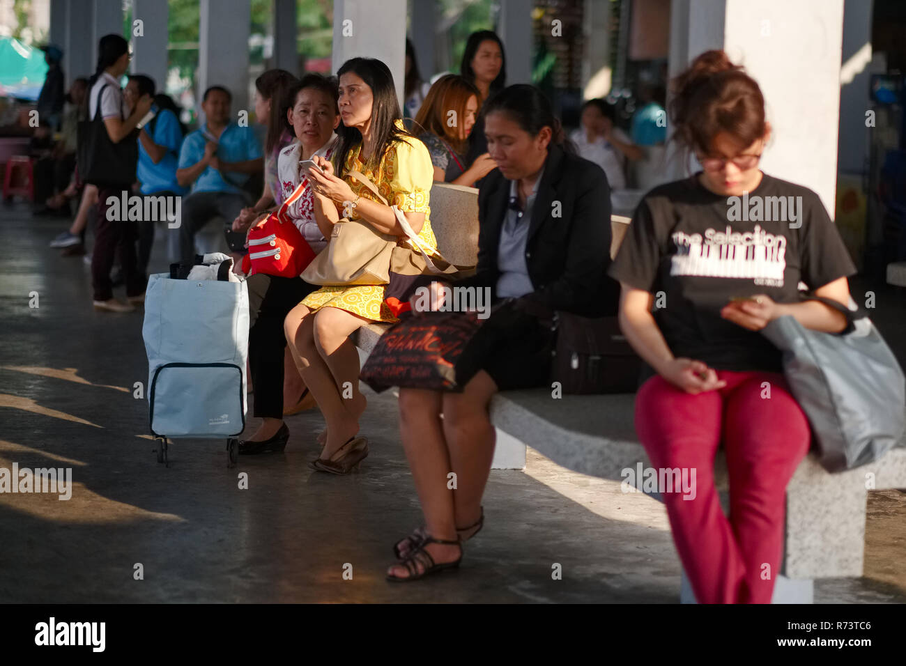 Passengers at a ferry pier near Bangkok, Thailand waiting for their boat Stock Photo