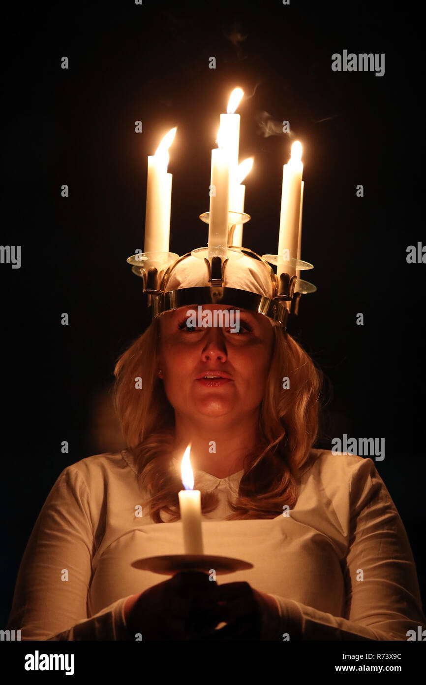 A woman symbolising St Lucy wearing a crown of candles leads a candlelit procession of the London Nordic Choir during the Sankta Lucia service at York Minster. Stock Photo