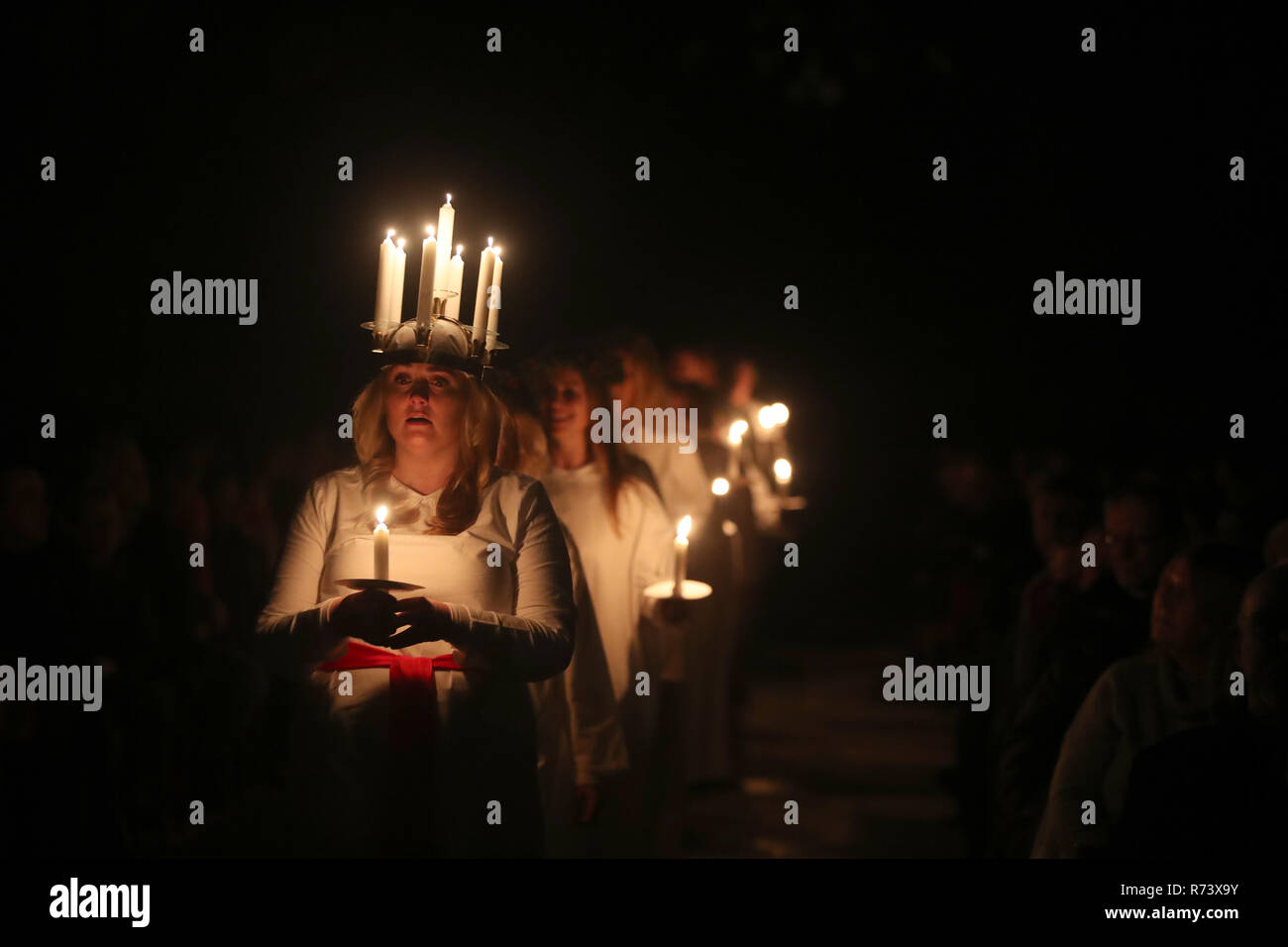 A woman symbolising St Lucy wearing a crown of candles leads a candlelit procession of the London Nordic Choir during the Sankta Lucia service at York Minster. Stock Photo
