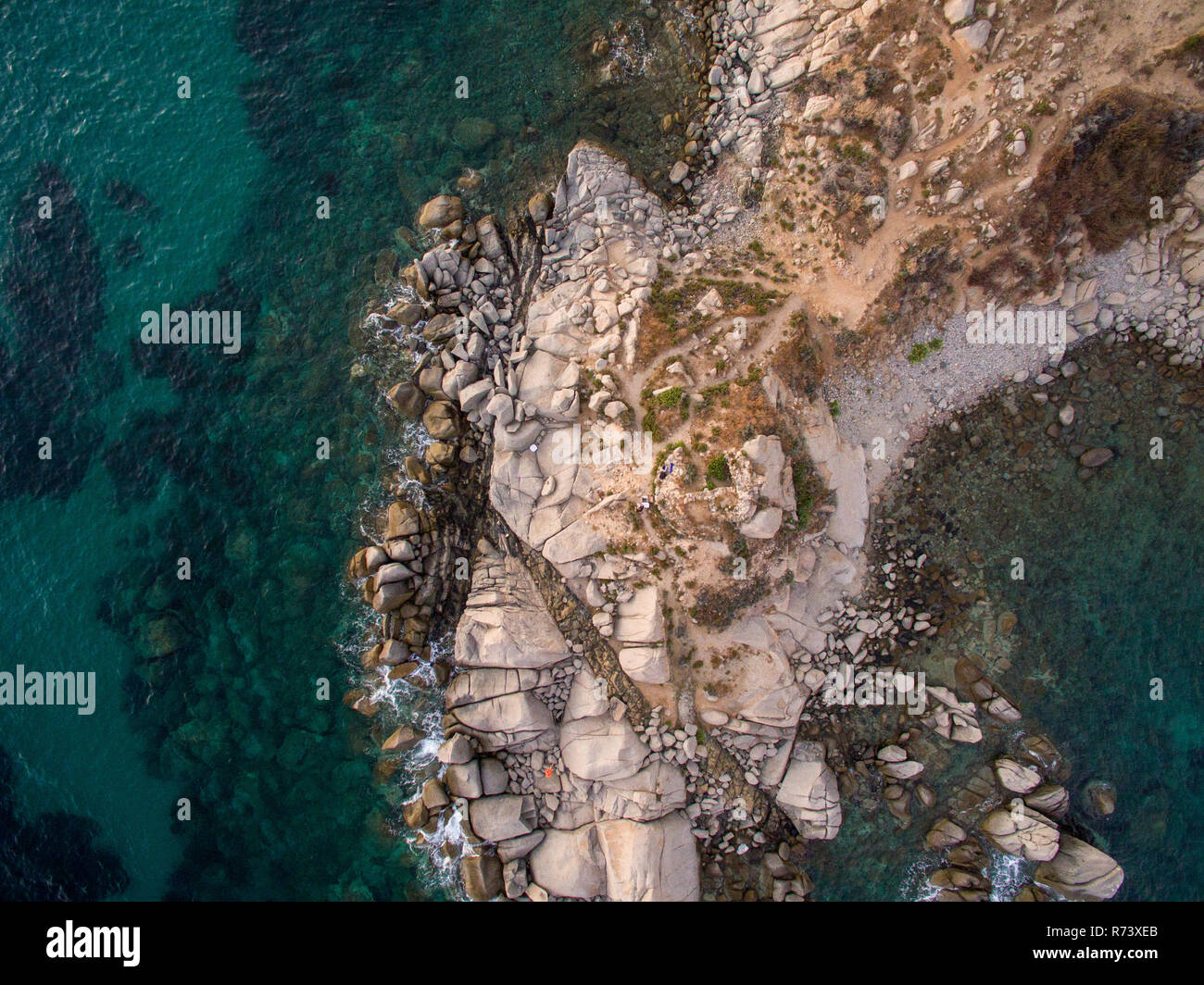 Aerial photography of the Sardinia coast during a summer sunset. Small waves on the rocks taken with a drone. Stock Photo
