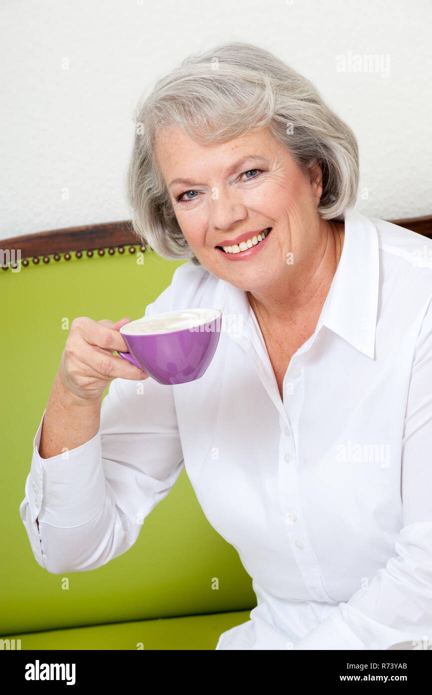 Mature woman sitting on sofa hi-res stock photography and images - Alamy