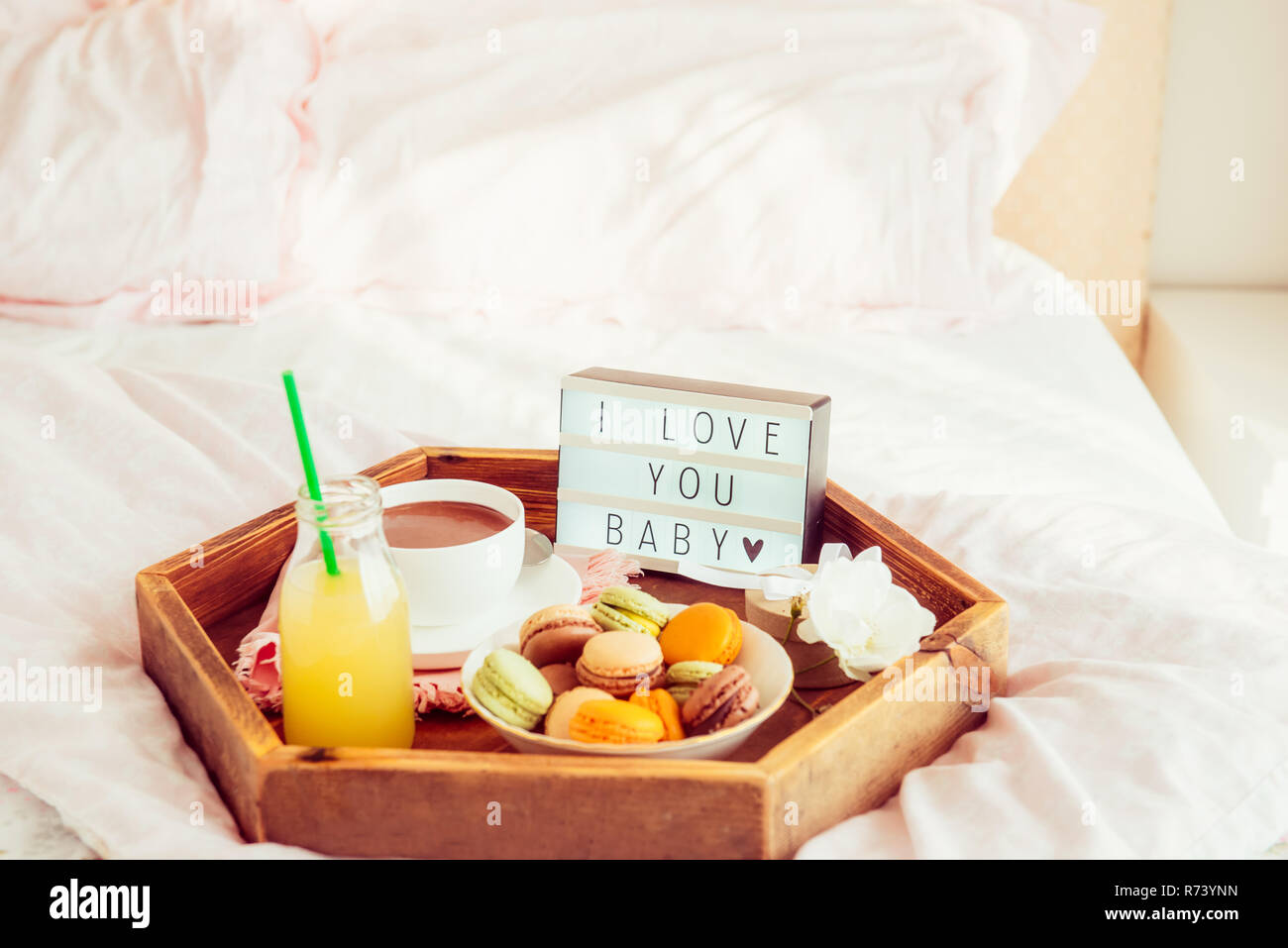https://c8.alamy.com/comp/R73YNN/romantic-breakfast-in-bed-with-i-love-you-baby-text-on-lighted-box-cup-of-coffee-juice-macaroons-flower-and-gift-box-on-wooden-tray-birthday-val-R73YNN.jpg