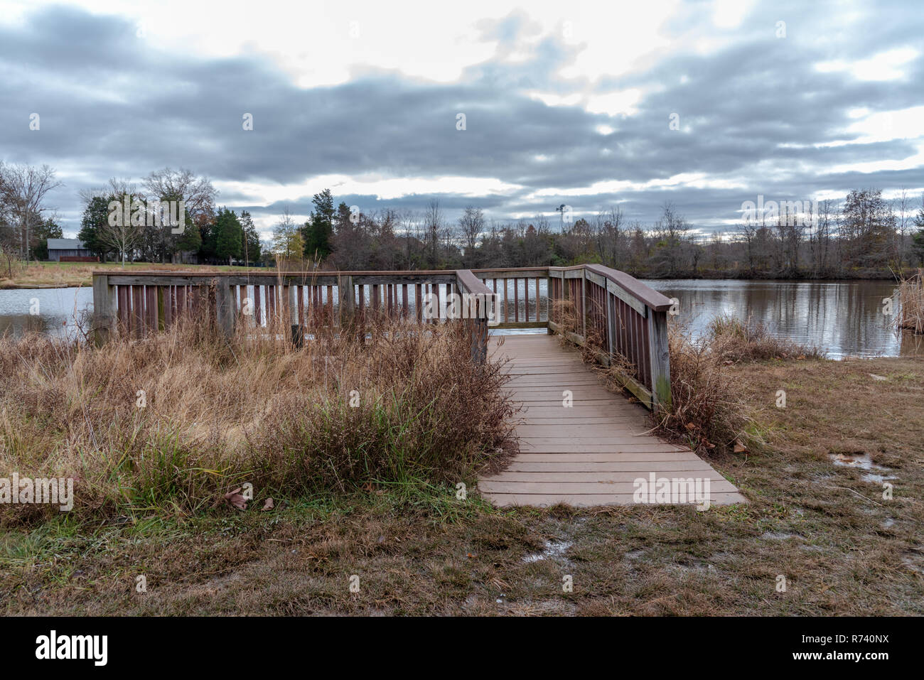 A wooden observation post looks out over a pond on a cold, wintery day; threatening skies are overhead. Stock Photo