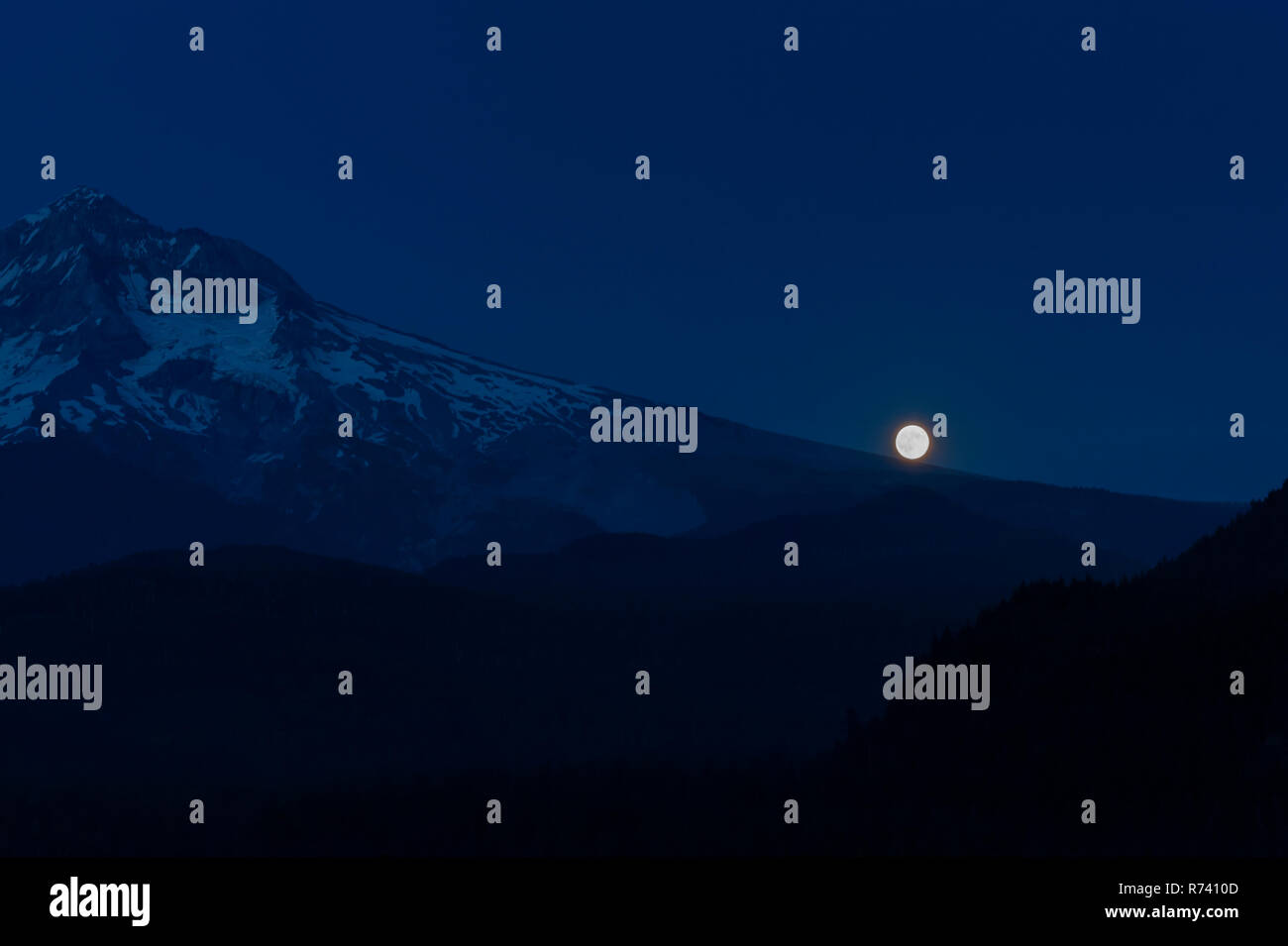 Full Moon rises along Mt. Hoods flanks in Mt. Hood National Forest Stock Photo