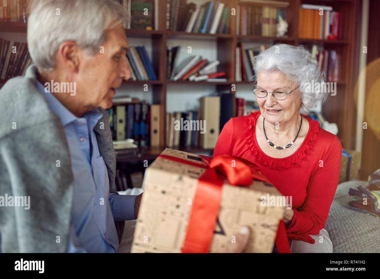 Happy lovely senior couple exchanging presents on Christmas Stock Photo
