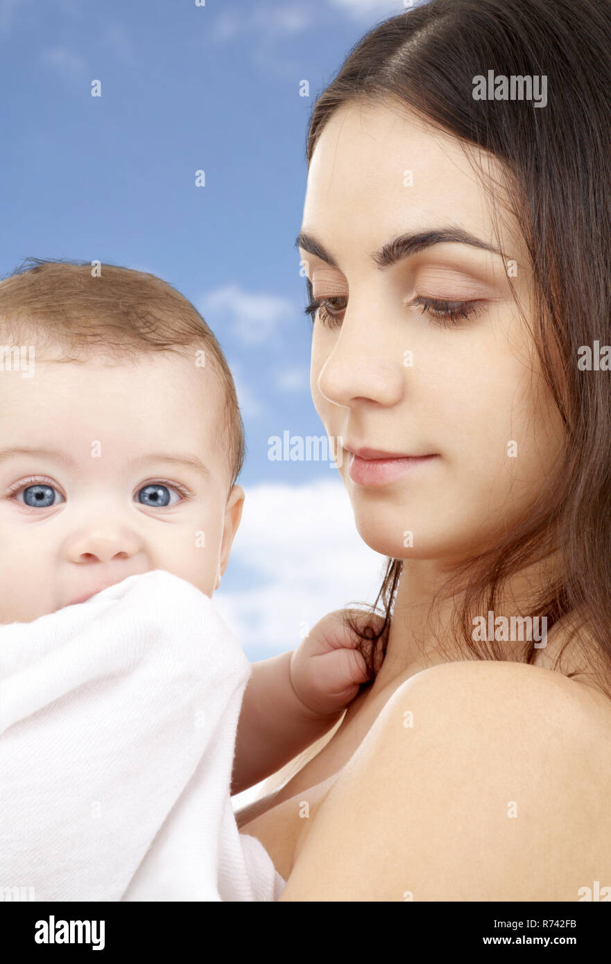 mother with baby in bath towel over sky background Stock Photo Alamy