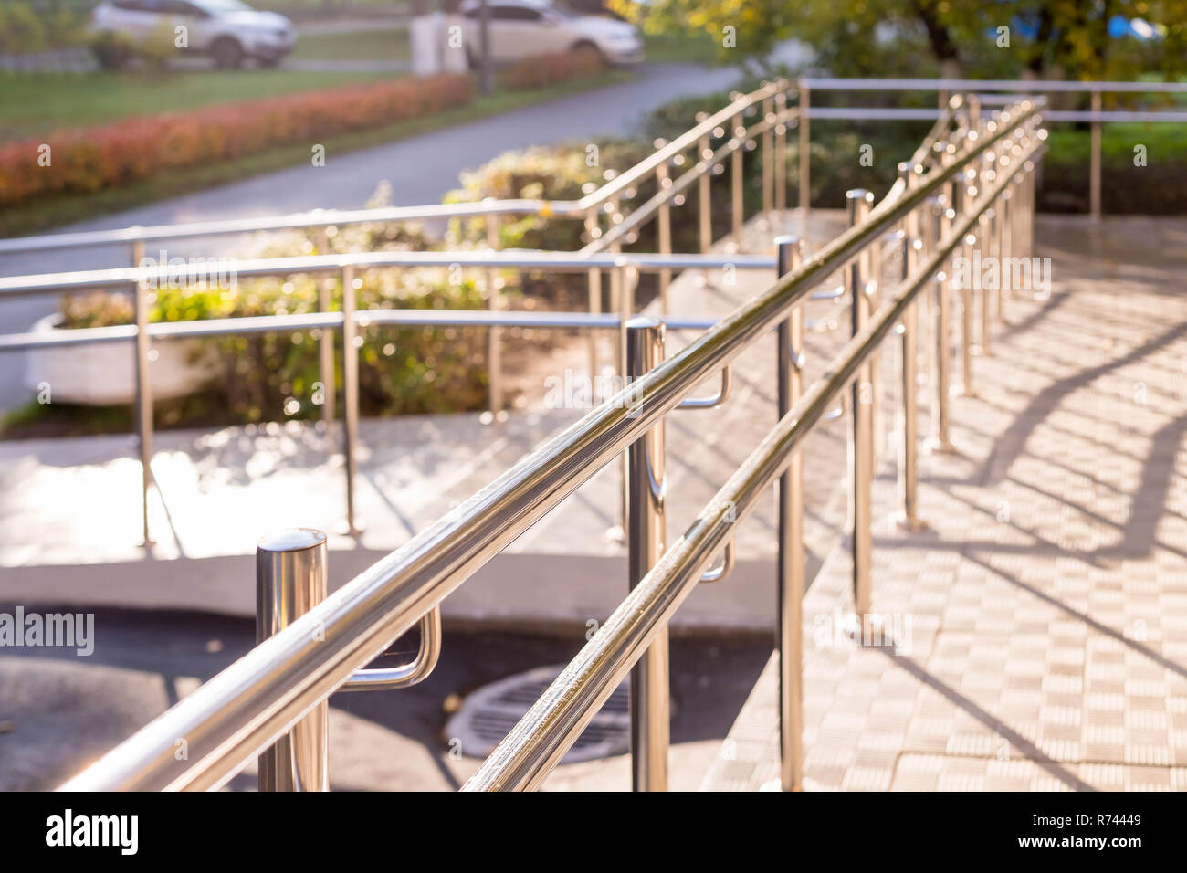 Concret ramp way with stainless steel handrail with disabled sign for