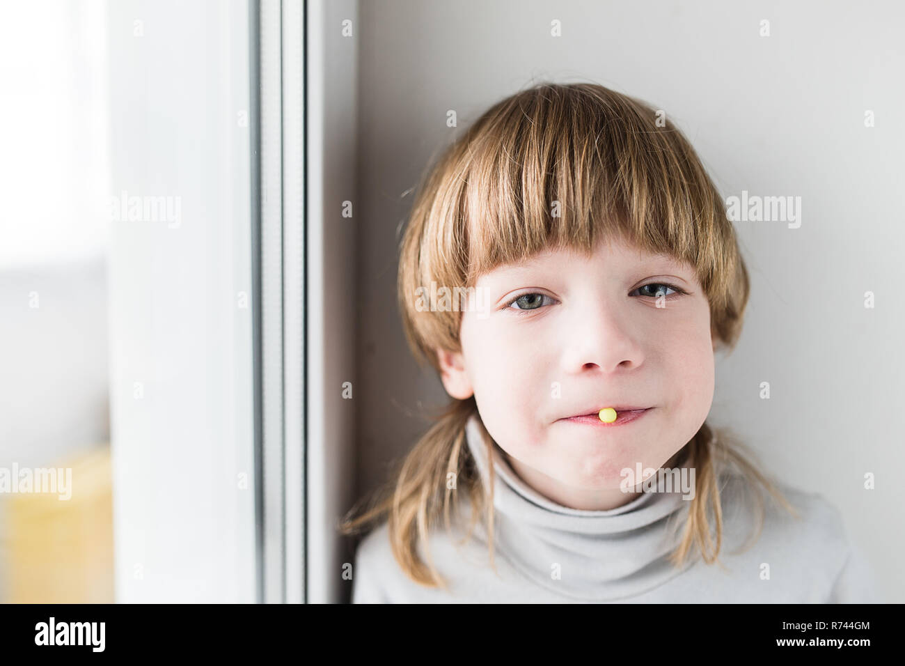 Little blonde boy taking drugs and take vitamins Stock Photo