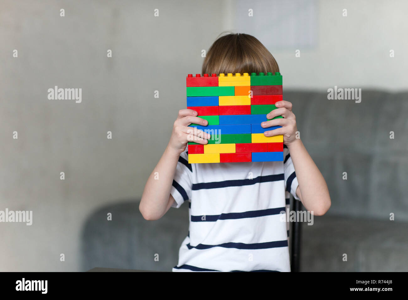Little kid boy playing with lots of colorful plastic blocks indoor ...