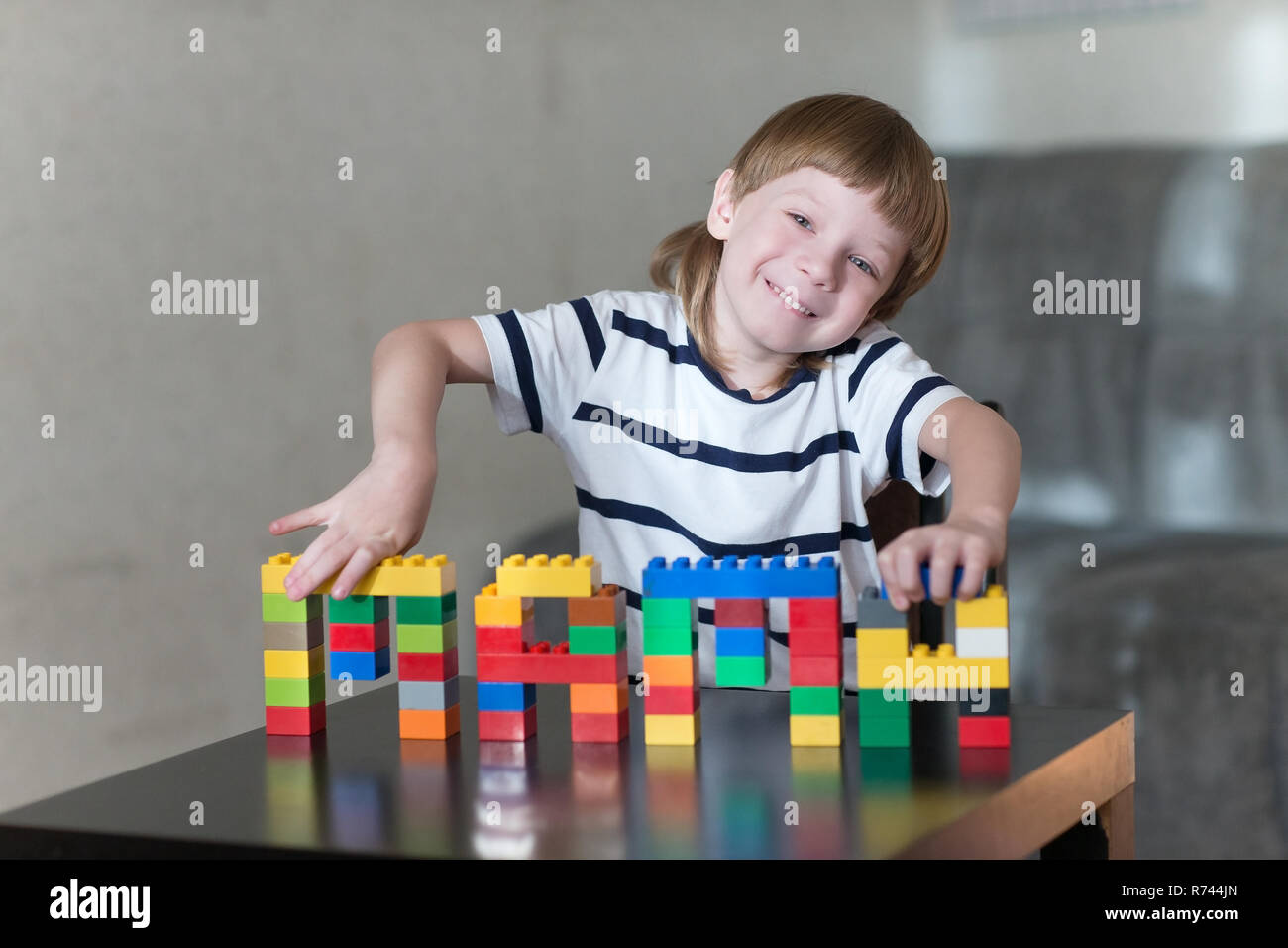 Little kid boy playing with lots of colorful plastic blocks indoor ...