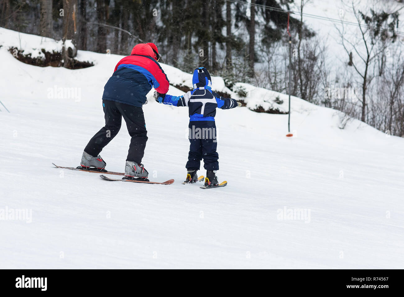 Female instructors teach a child skiing on winter resort Stock Photo