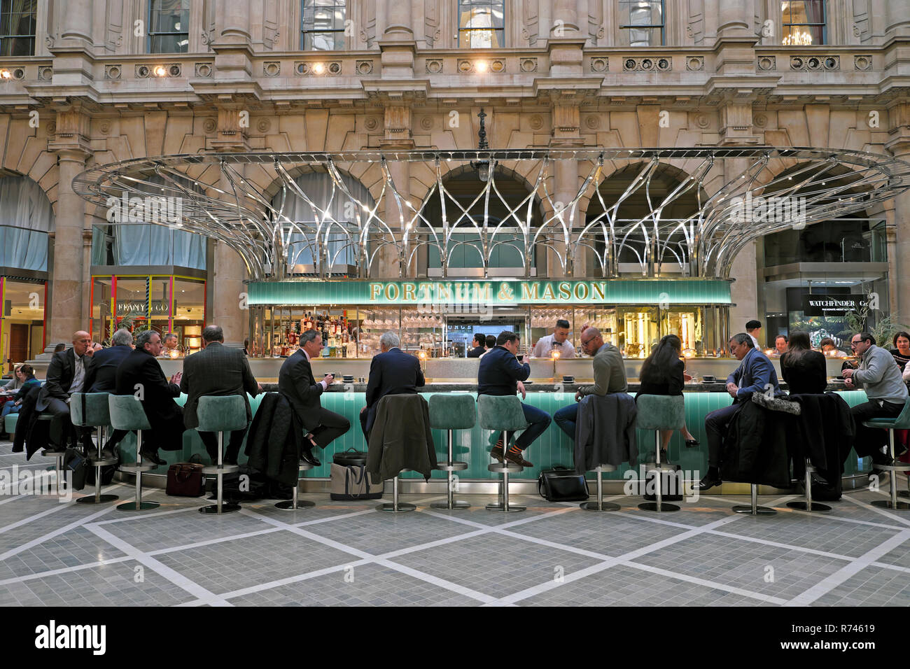 Fortnum & Mason sign and customers at the bar restaurant inside the Royal Exchange in the City of London during Christmas in England UK  KATHY DEWITT Stock Photo