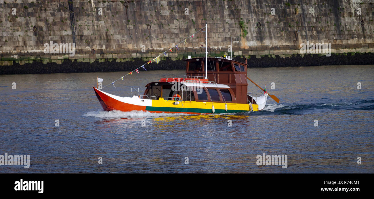 An empty rabelo boat sails along the Douro River in Porto, Portugal. Side Front View. Stock Photo