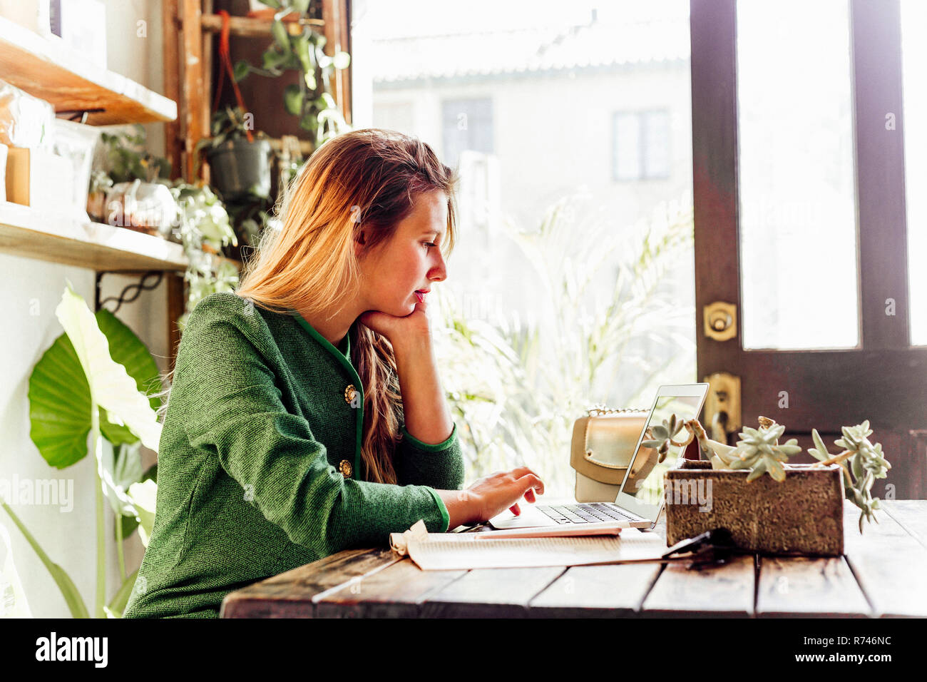 Young woman using laptop in cafe Stock Photo