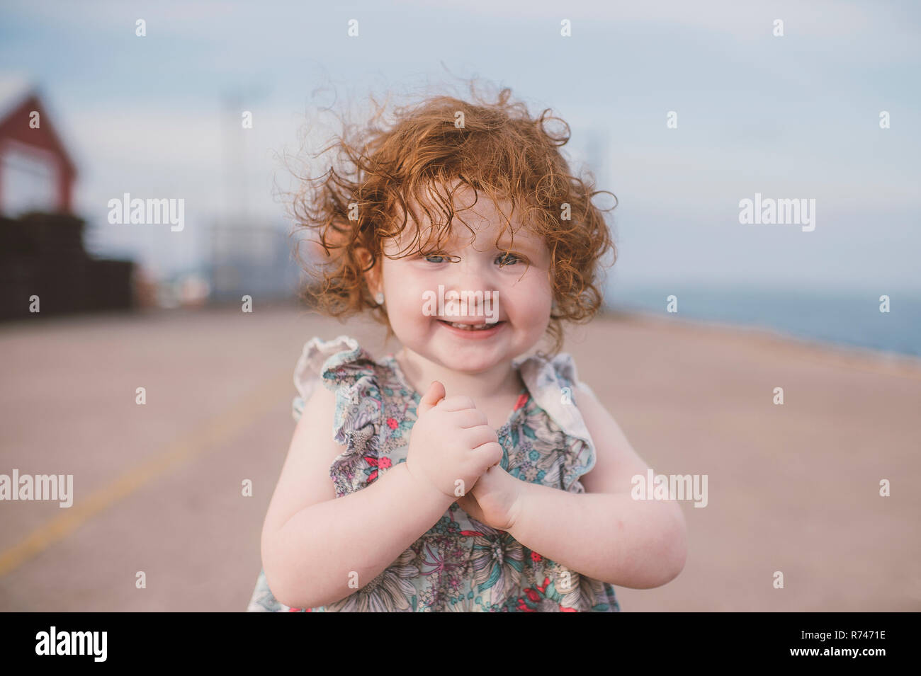 Girl with curly red hair at coast, portrait Stock Photo