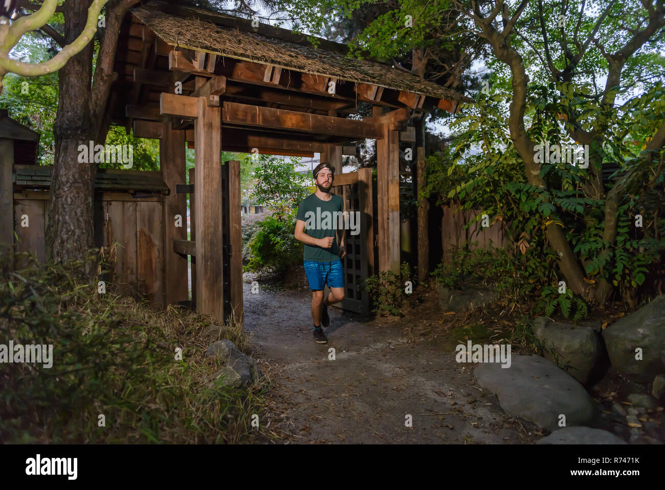 Runner going under entrance of park, North Vancouver, Canada Stock Photo