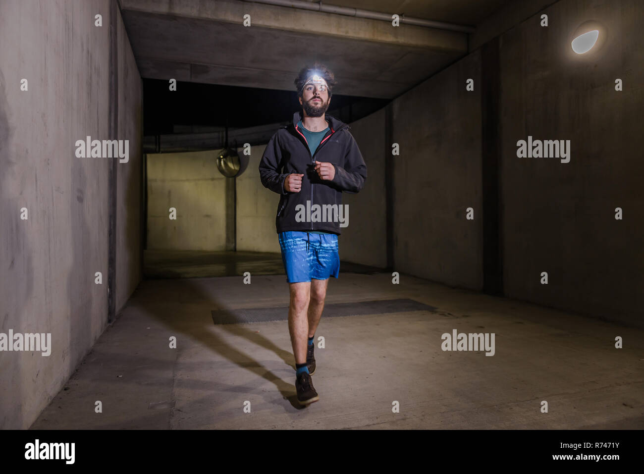 Runner with headlamp in tunnel Stock Photo