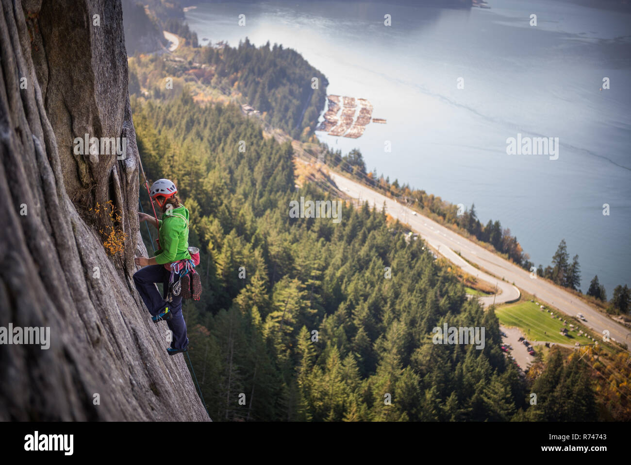 Young female rock climber climbing rock face, elevated view, The Chief, Squamish, British Columbia, Canada Stock Photo