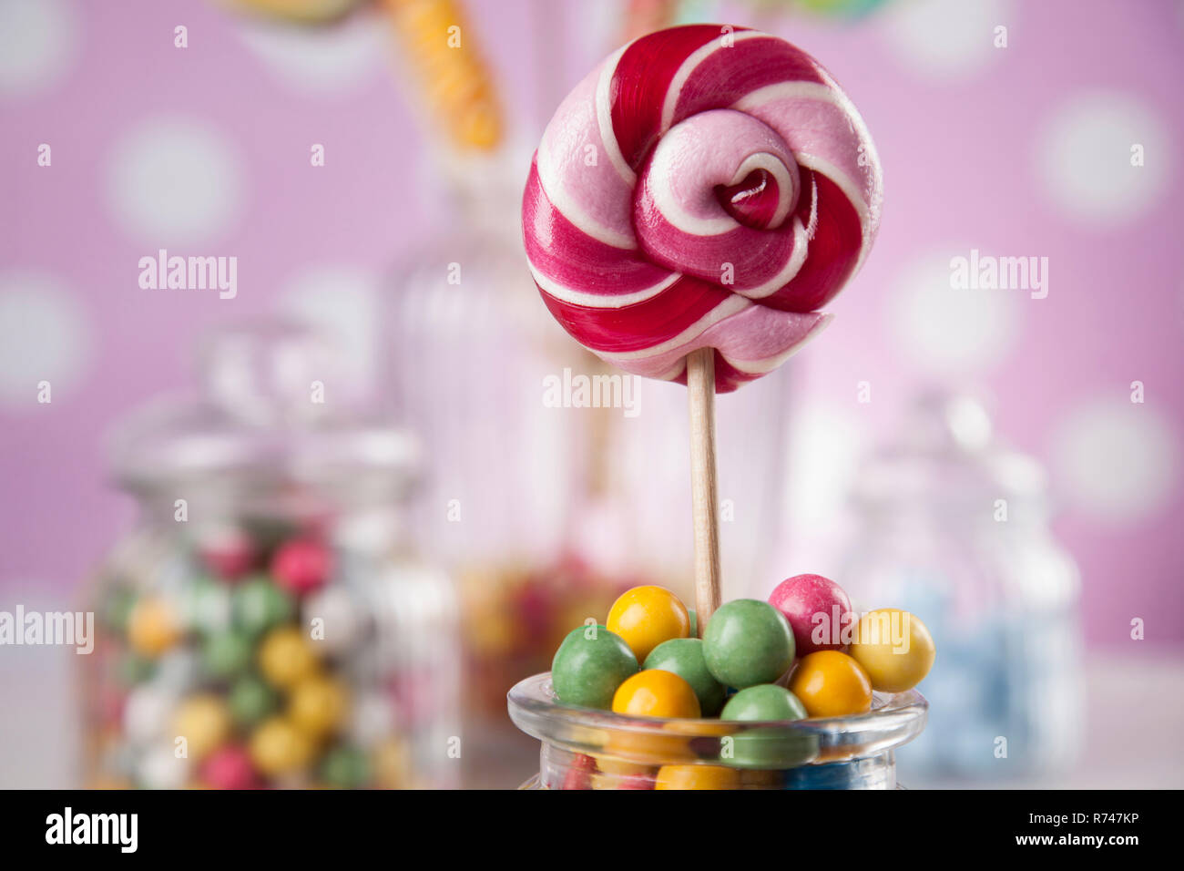 Colorful lollipops and different colored round candy and gum balls ...