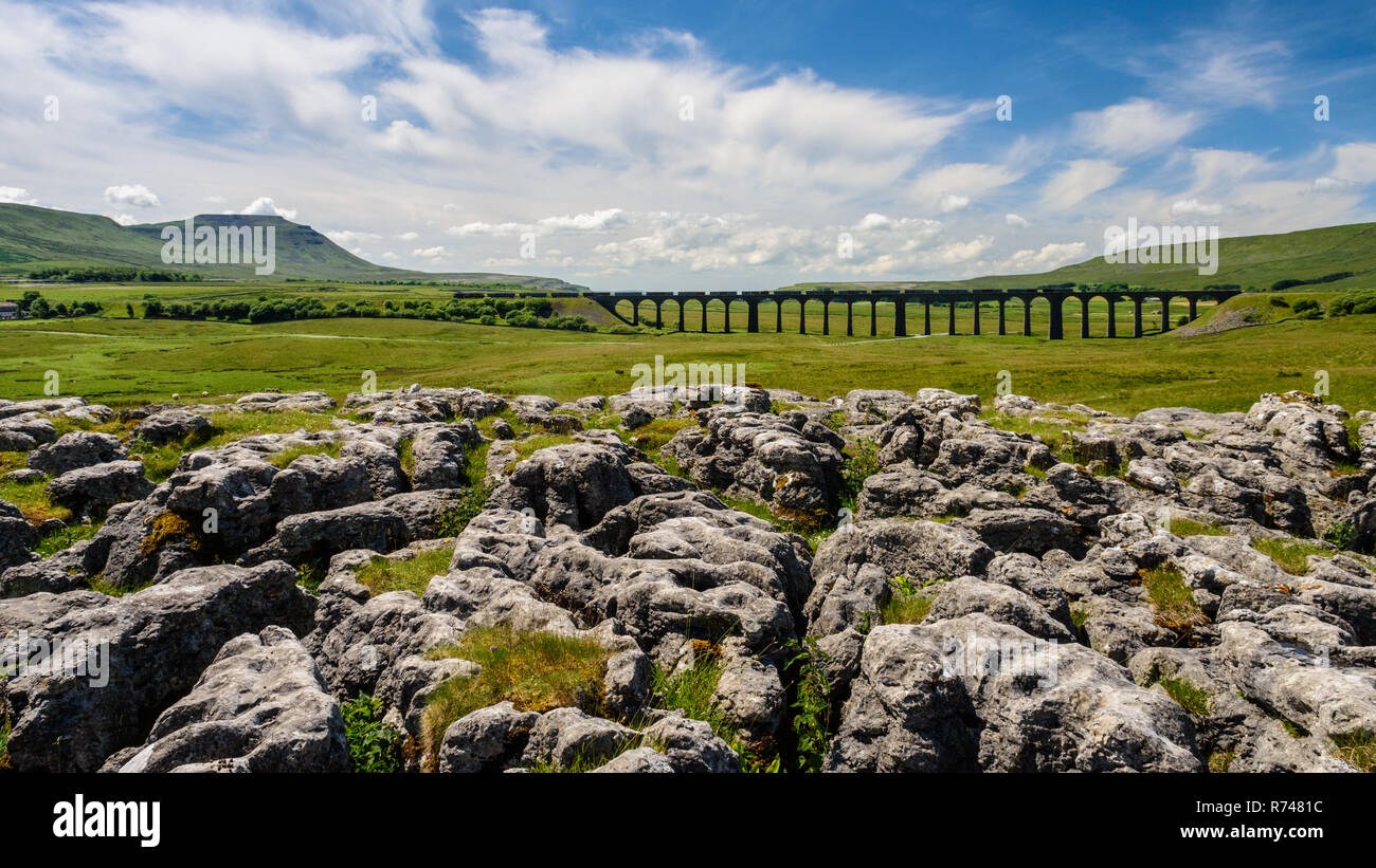 Ribblehead, England, UK - July 3, 2015: A train of freight containers crosses the Ribblehead Viaduct on the scenic Settle and Carlisle railway in Engl Stock Photo