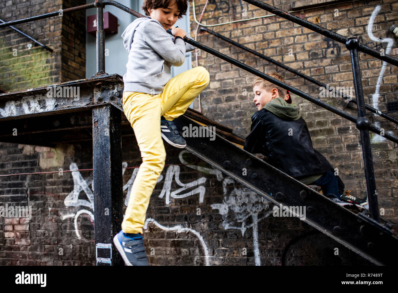 Boys playing on metal staircase Stock Photo
