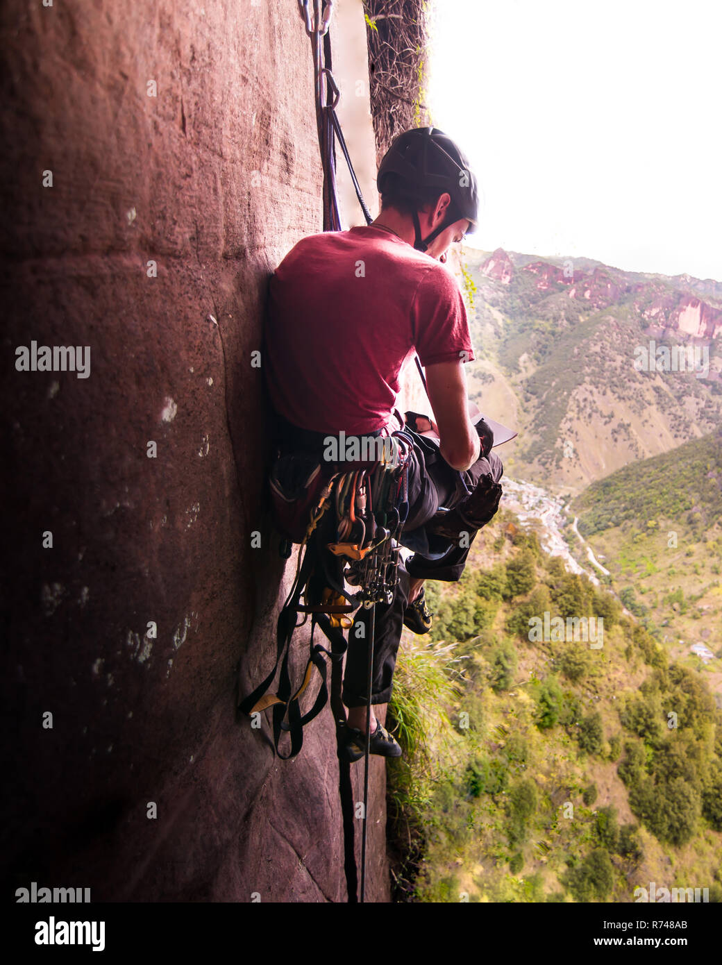 Rock climber sitting by rock face, Liming, Yunnan, China Stock Photo