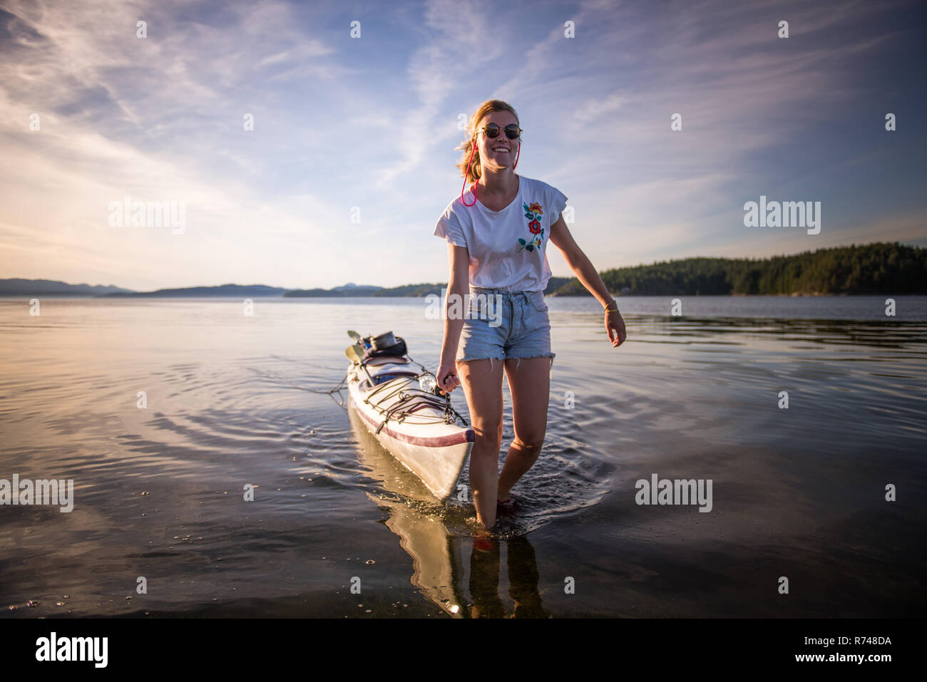 Young female kayaker pulling kayak, Quadra Island, Campbell River