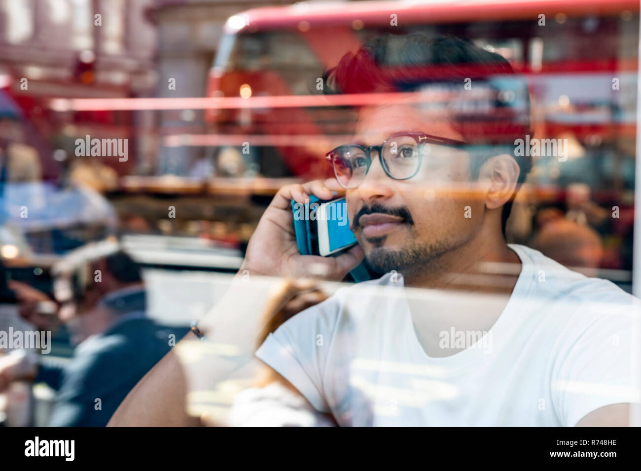 Man using smartphone in cafe Stock Photo