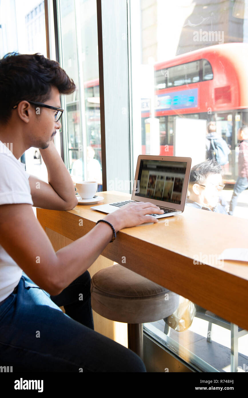 Man using laptop in cafe Stock Photo